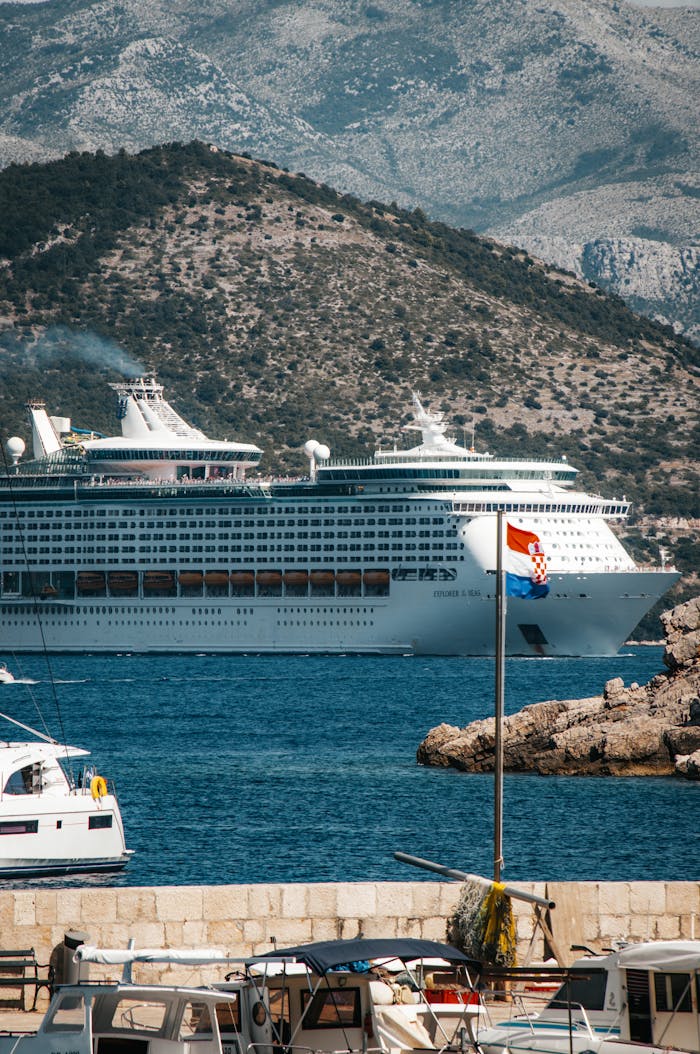 Large cruise ship sailing in the Adriatic Sea near Dubrovnik under a clear summer sky.